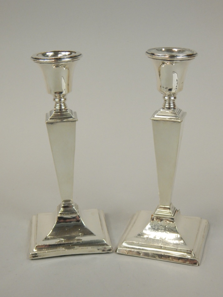 Appraisal: A pair of George V silver candlesticks each with a