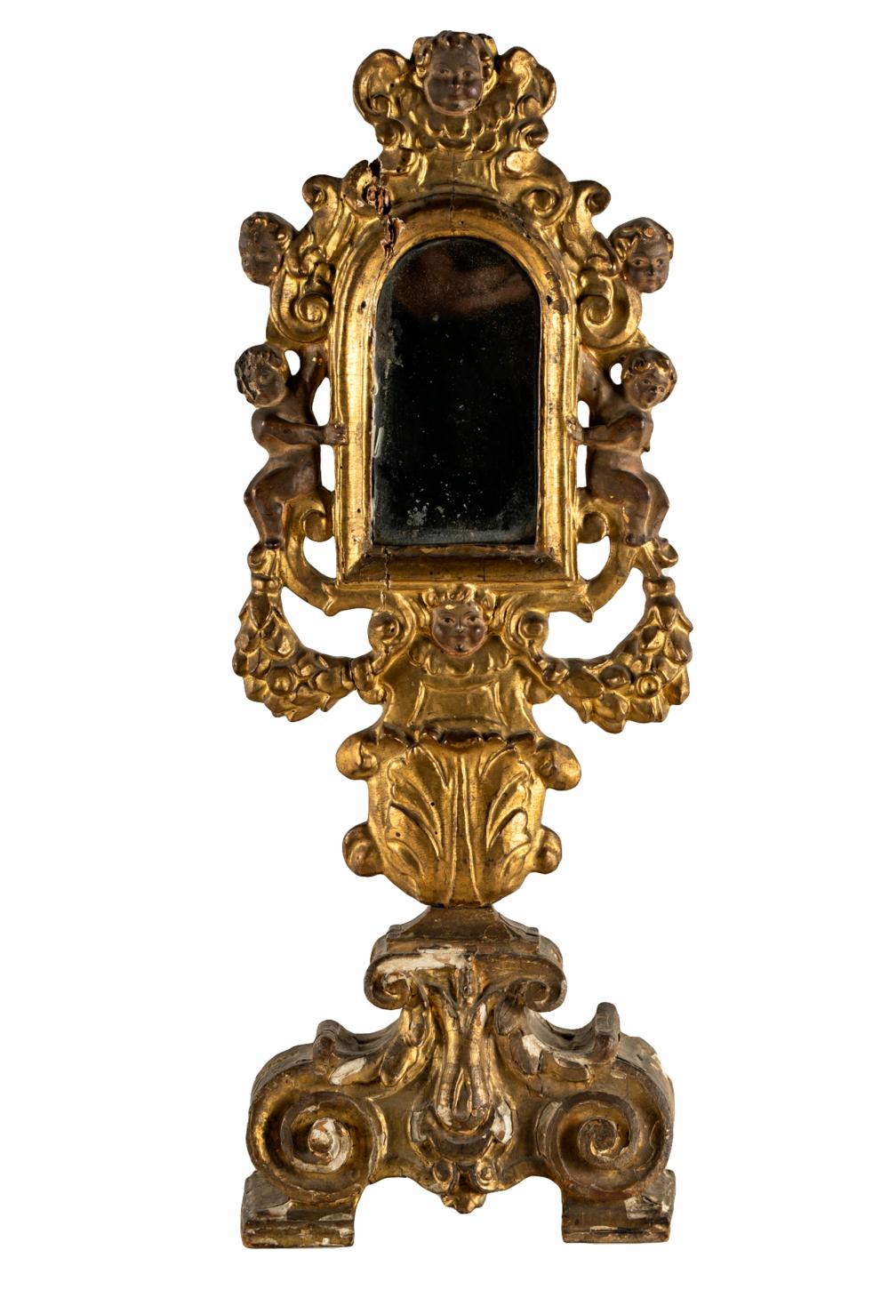 Appraisal: GILDED TABLE MIRRORwood carved putti decoration Condition loss to paint