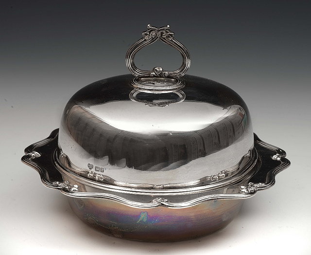 Appraisal: A silver muffin dishof circular form with shaped handle and