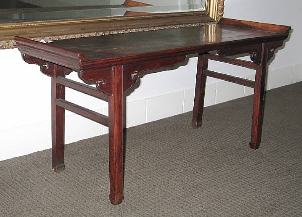 Appraisal: A rosewood rectangular table With scrolling ends and cloud-form aprons