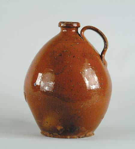 Appraisal: FINE HANDLED OVOID REDWARE JUG Orange brown glaze Nice form