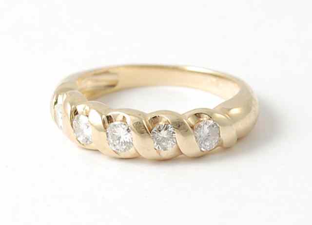 Appraisal: DIAMOND AND FOURTEEN KARAT GOLD RING set with a row