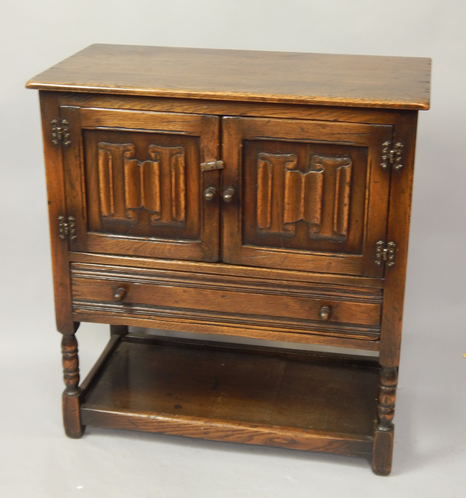 Appraisal: A reproduction oak side cabinet with two linenfold doors