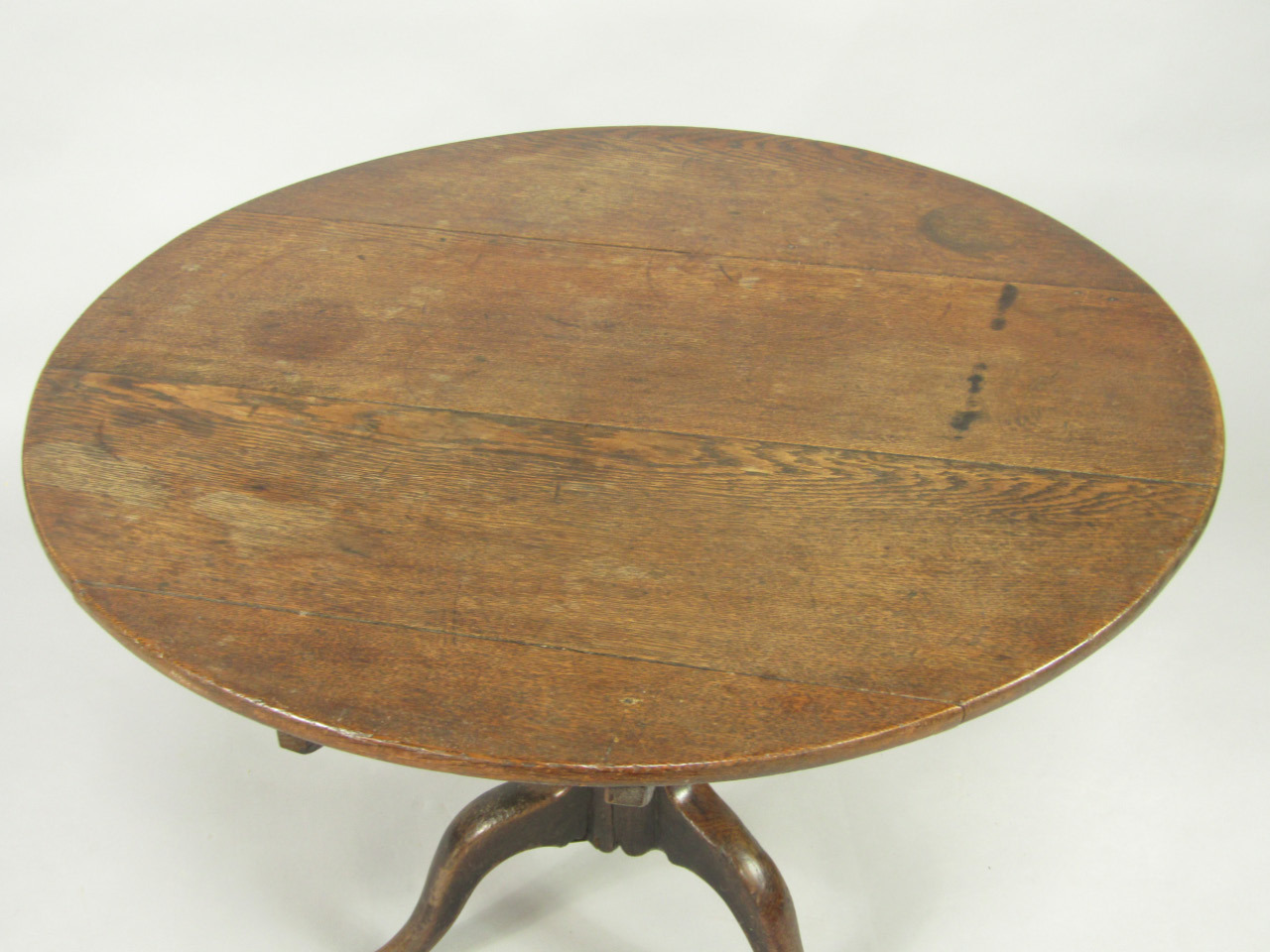 Appraisal: A George III oak tilt top circular occasional table raised