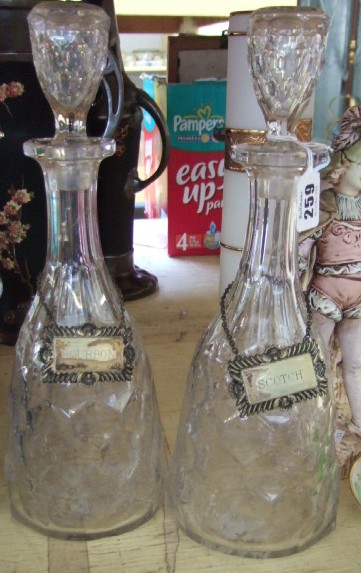 Appraisal: A pair of cut glass decanters with plated labels