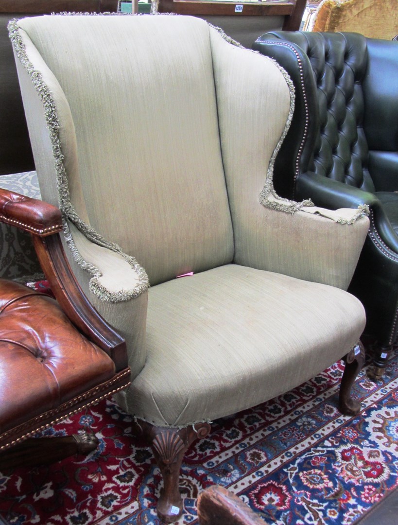 Appraisal: A wingback armchair of George I design on shell capped