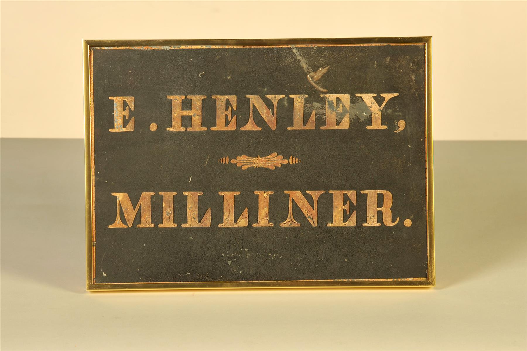 Appraisal: E HENLEY MILLINER SIGN American nd half- th century Tin