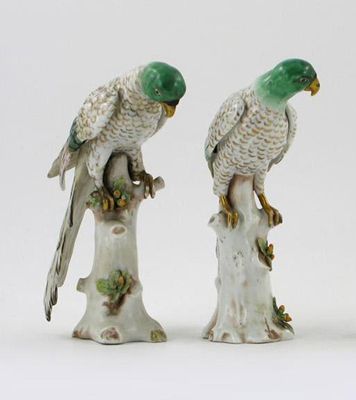 Appraisal: A pair of continental figures of a parrot seated on