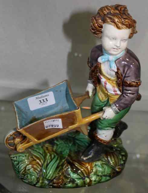 Appraisal: A TH CENTURY MAJOLICA FIGURE showing a young boy pushing