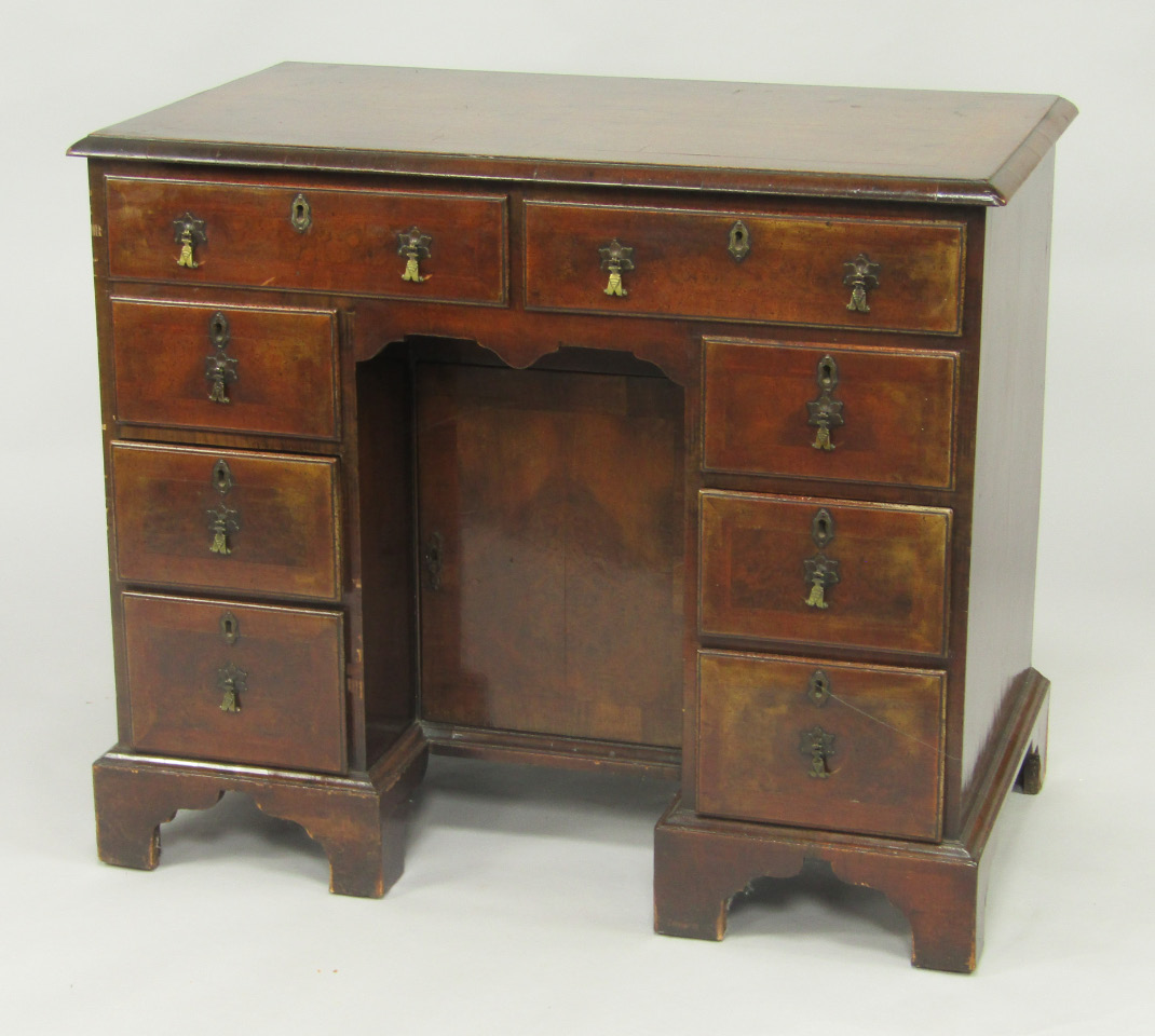 Appraisal: A George II walnut and cross banded kneehole desk with