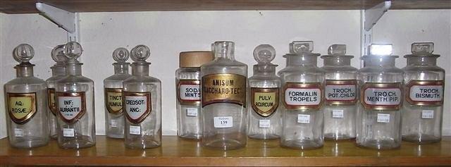 Appraisal: A COLLECTION OF CLEAR GLASS DRUG JARS with various stoppers