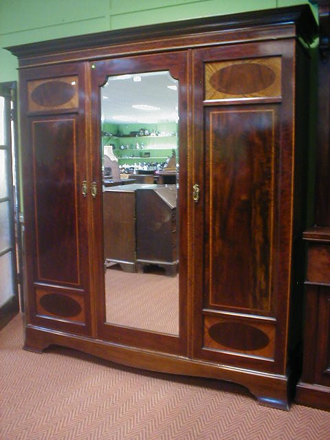 Appraisal: An Edwardian mahogany three door wardrobe with oak linen press