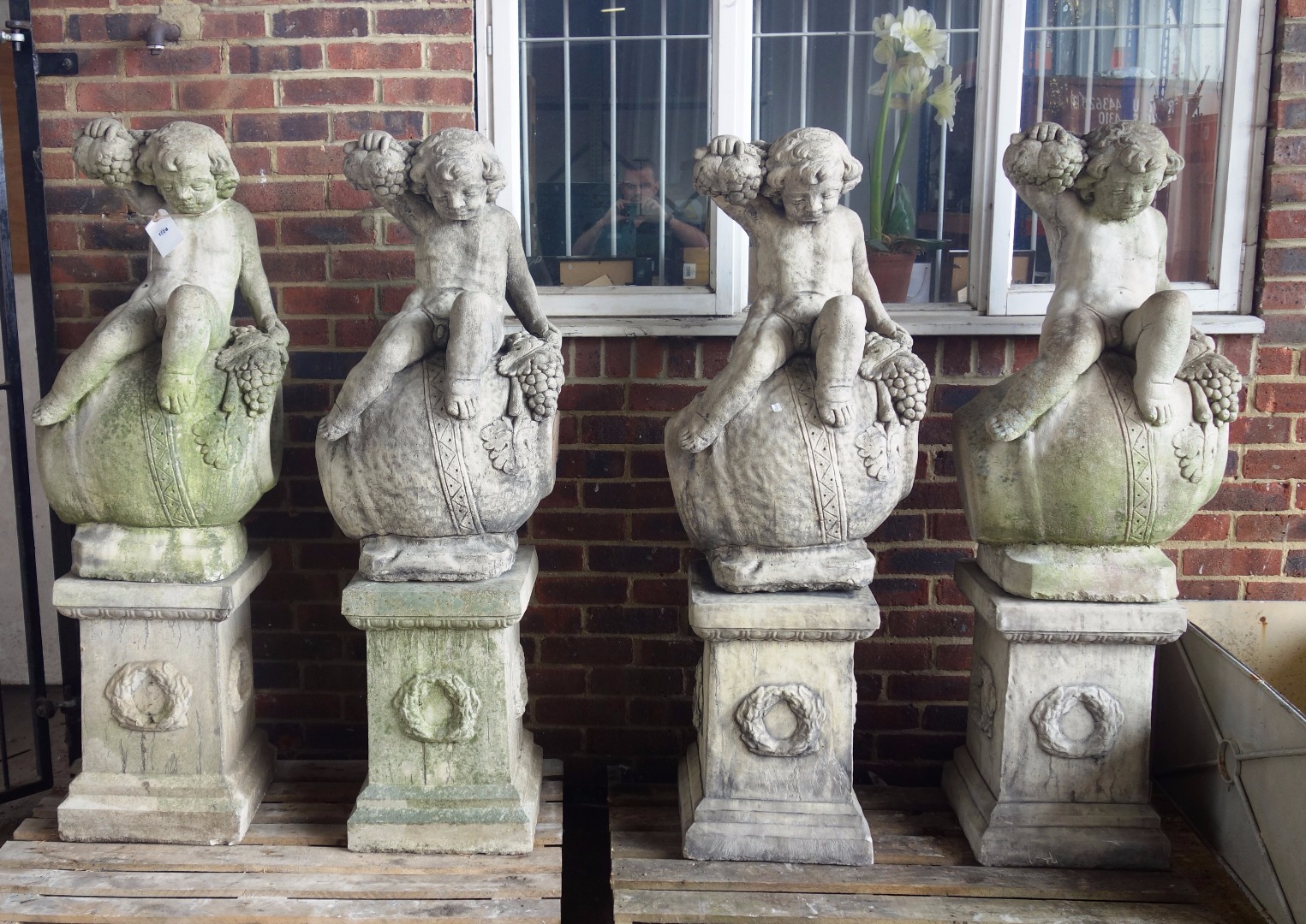 Appraisal: A set of four reconstituted stone figures of cherubs sat