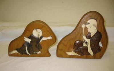 Appraisal: A PAIR OF ORIENTAL IVORY PLAQUES carved as two boys