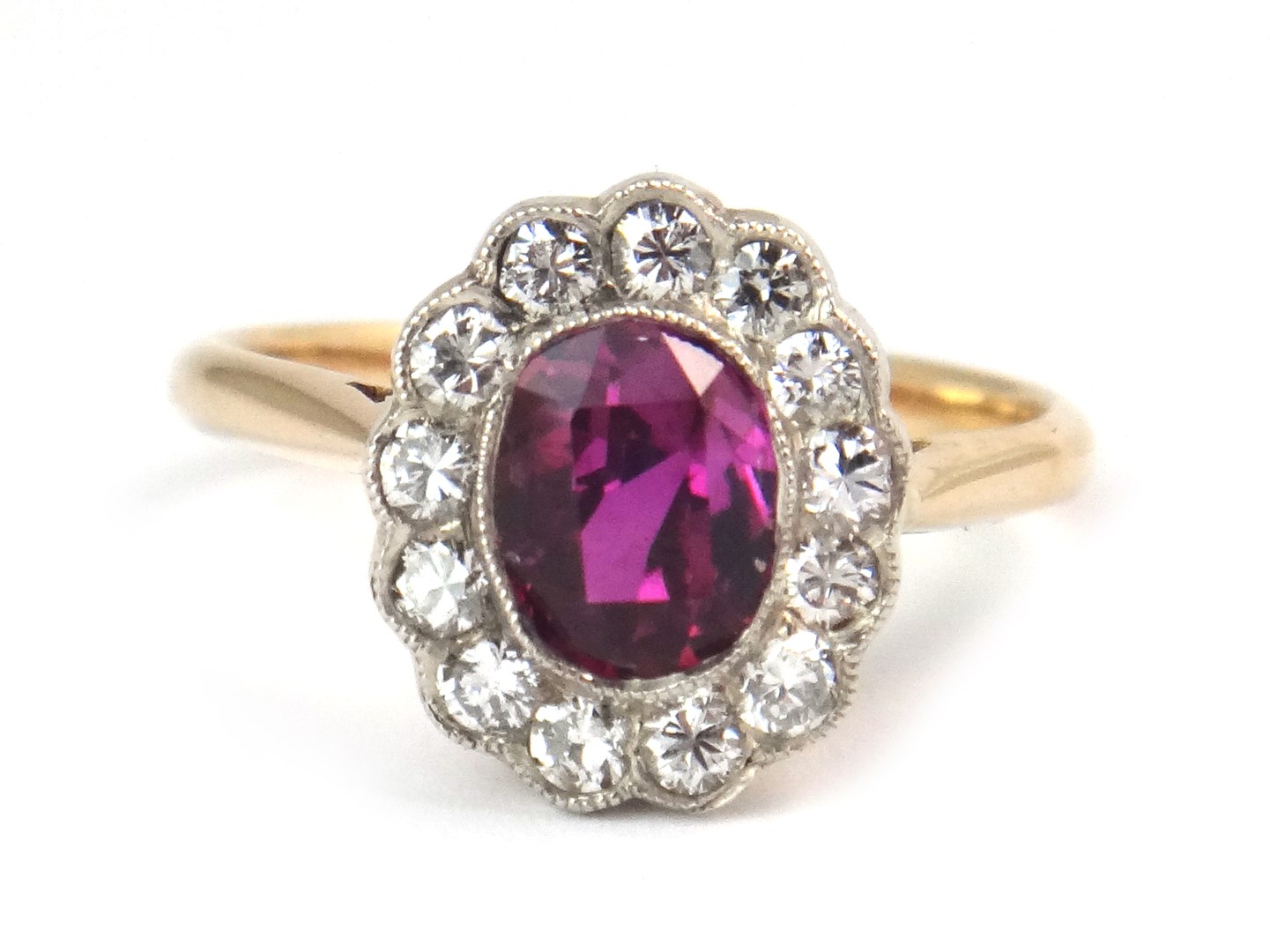 Appraisal: A gold diamond and magenta coloured sapphire oval cluster ring