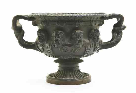 Appraisal: A Patinated Bronze Urn having X-form handles decorated with busts