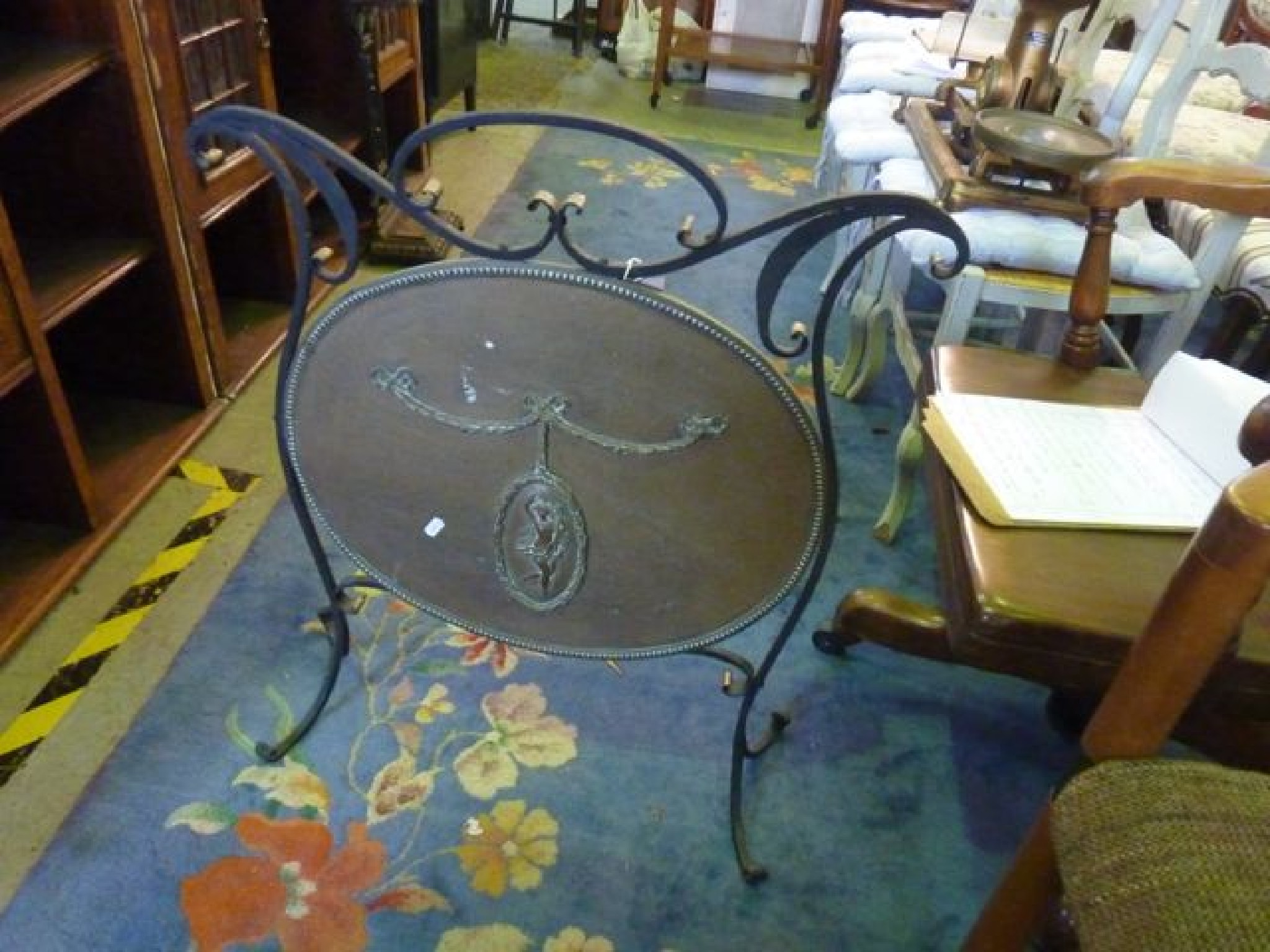 Appraisal: An Edwardian ironwork firescreen with oval brass plate centre