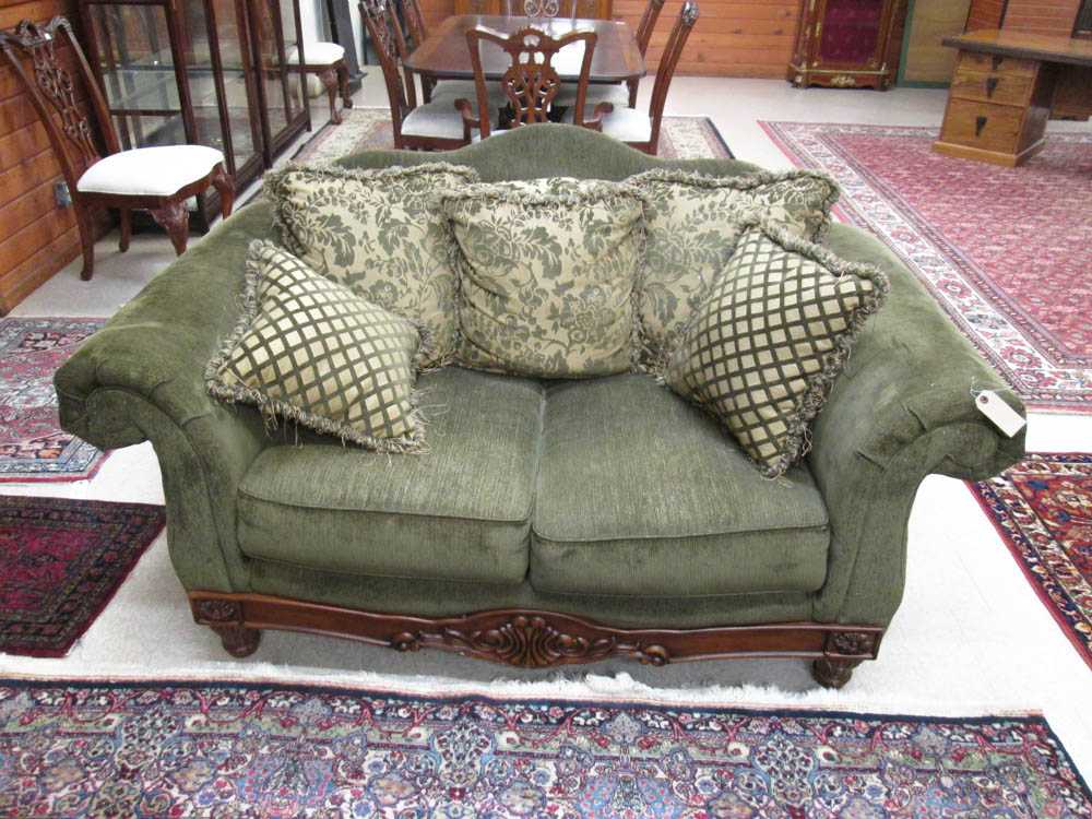 Appraisal: GREEN UPHOLSTERED AND CARVED MAHOGANY FINISH LOVESEAT Ashley Furniture Industries