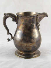 Appraisal: A Georgian silver baluster beer jug with leaf capped double