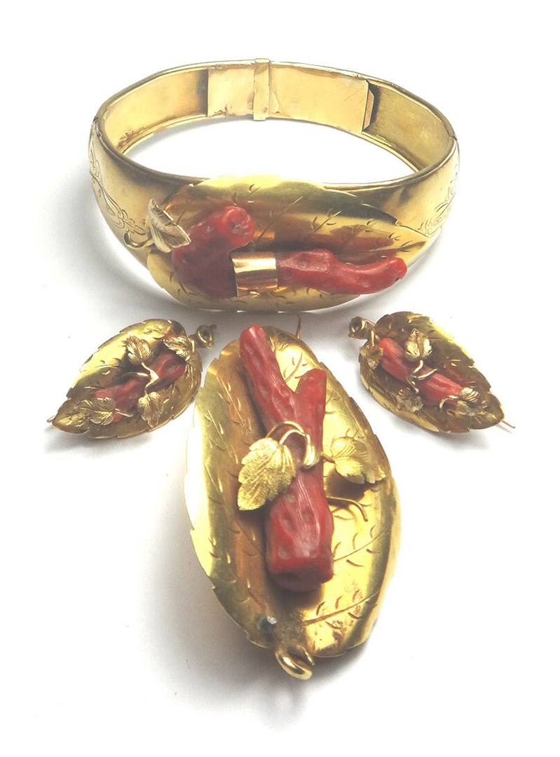 Appraisal: A gold and coral set oval hinged bangle with a