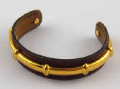 Appraisal: Hermes A gold plated metal and leather bangle by Hermes