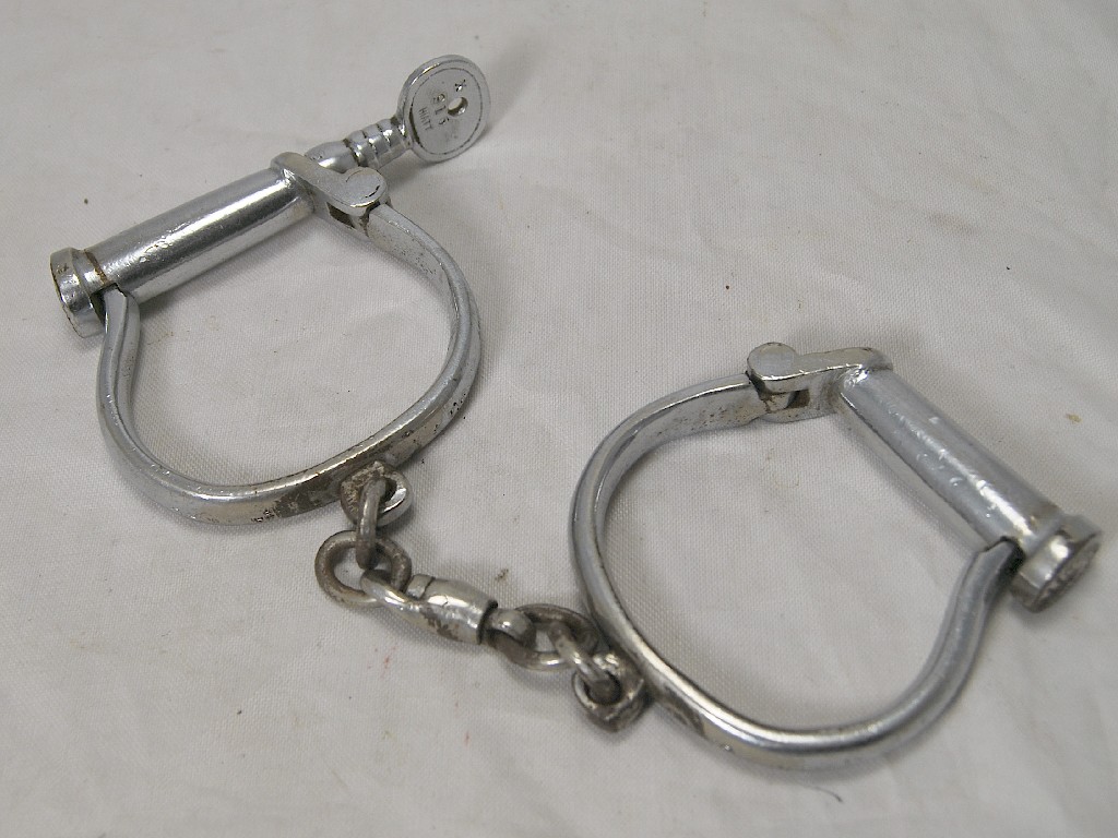 Appraisal: A pair of vintage chromium plate handcuffs with key