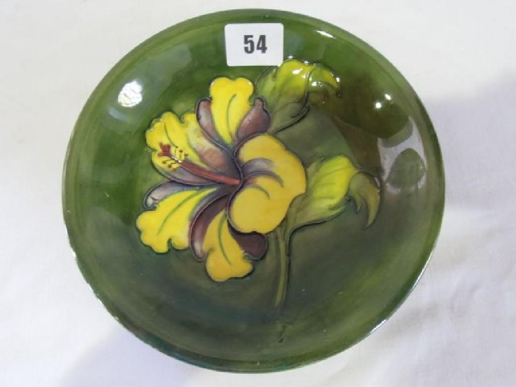 Appraisal: A Moorcroft dish with piped floral decoration on a green