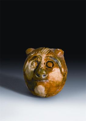 Appraisal: A Chinese pottery sancai-glazed bear's head whistle Tang dynasty -