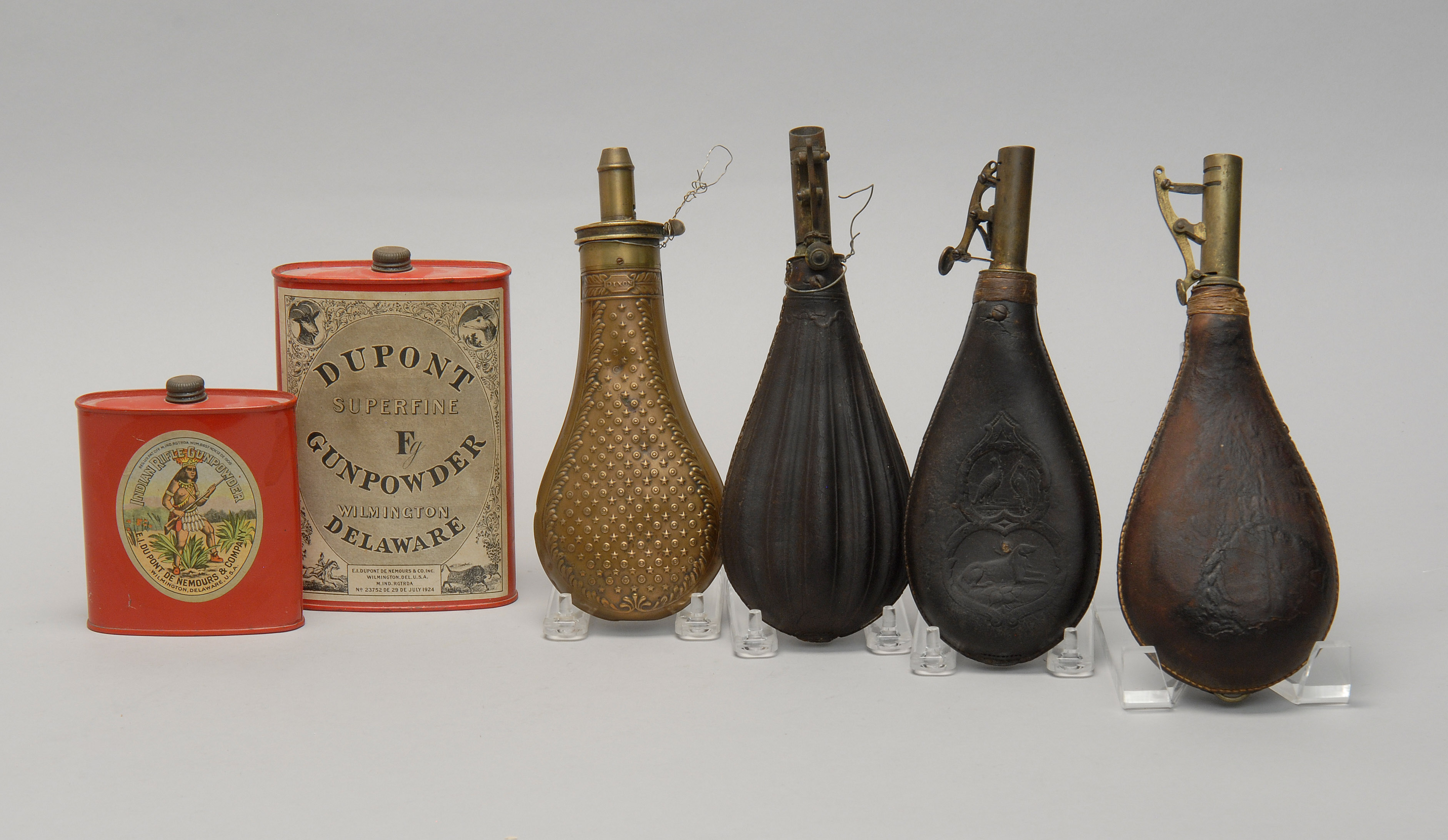 Appraisal: FOUR LEATHER AND BRASS POWDER FLASKS th CenturyTogether with two