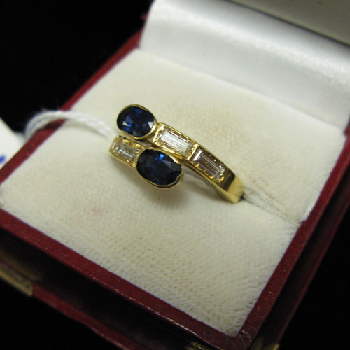 Appraisal: DIAMOND BLUE SAPPHIRE AND EIGHTEEN KARAT GOLD RING The crossover