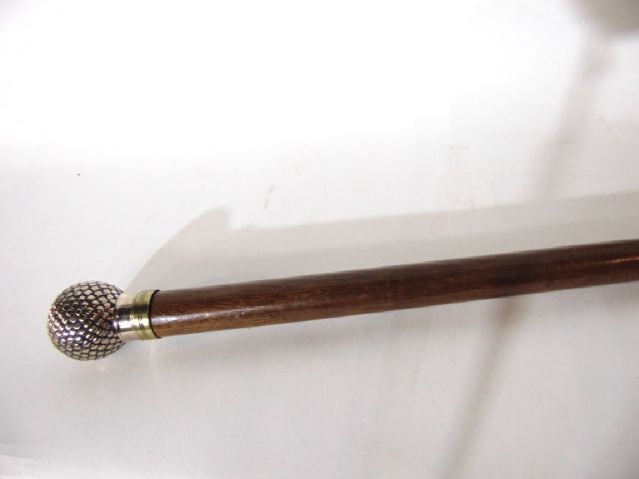 Appraisal: A tapering timber walking cane terminating in a white metal