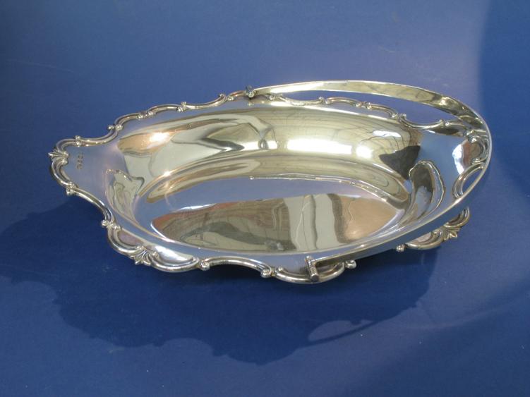 Appraisal: A SWING-HANDLED DISH of shaped oval form with a raised