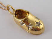 Appraisal: A yellow metal tests carat gold diamond set shoe pendant