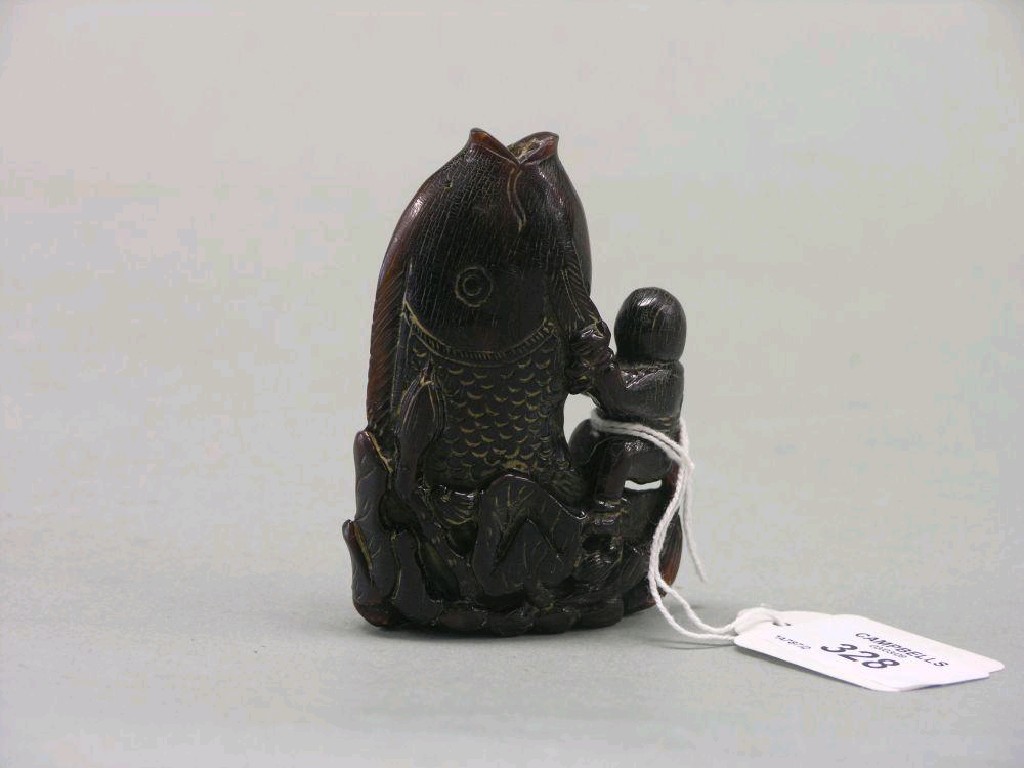 Appraisal: An oriental horn carving young boy holding onto a giant