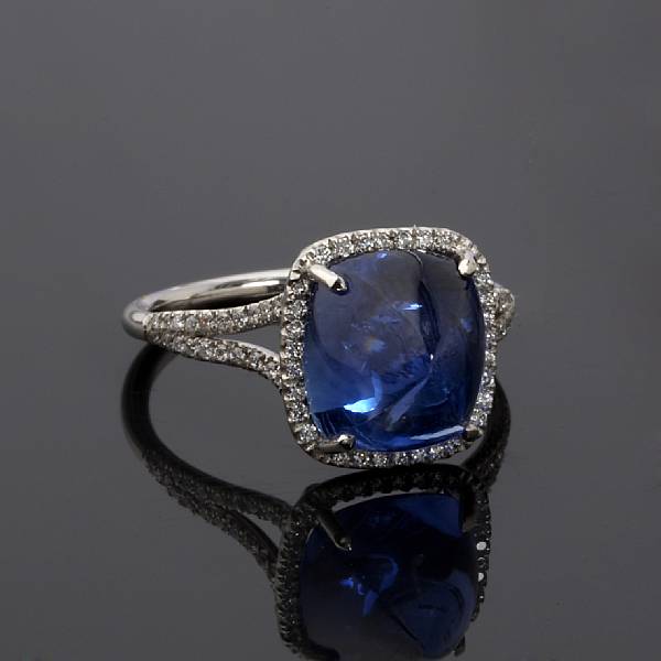 Appraisal: A sapphire and diamond ring centering a sugarloaf-cut sapphire estimated