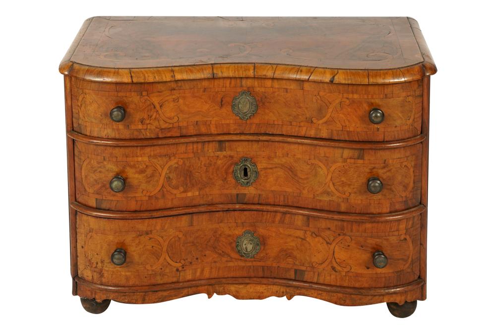 Appraisal: DIMINUTIVE CONTINENTAL WALNUT MARQUETRY COMMODEthe serpentine top above three conforming