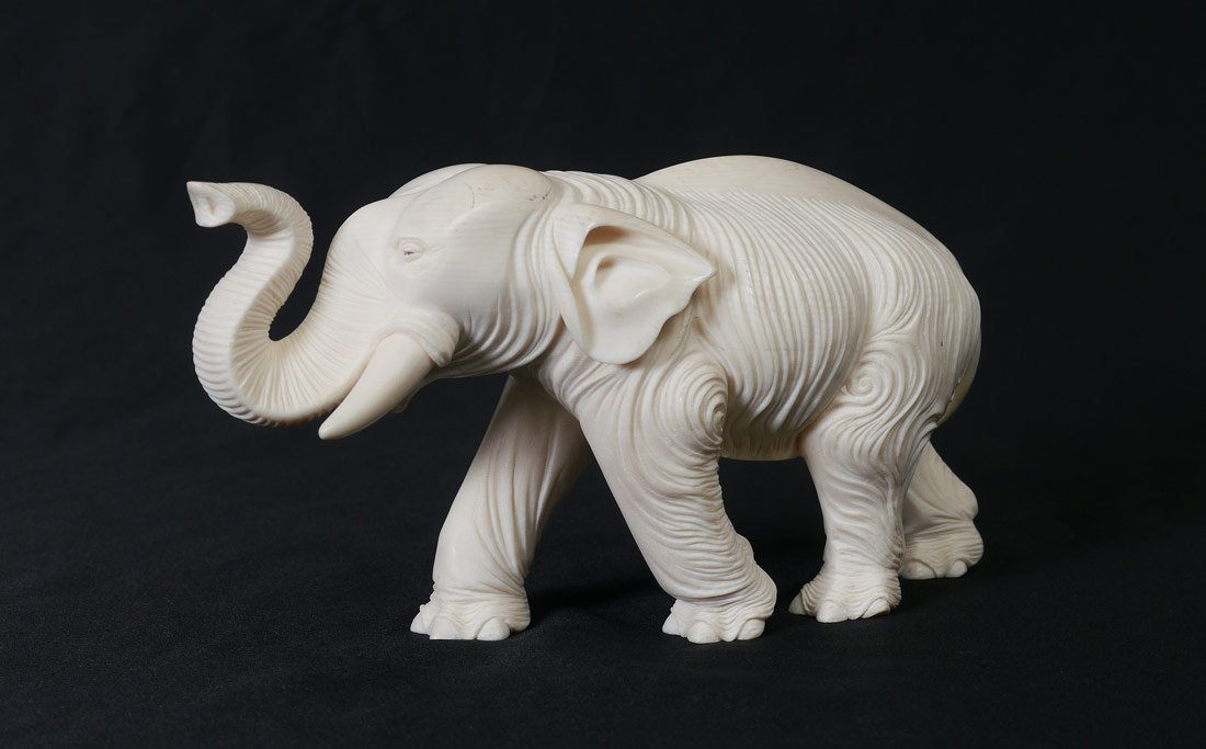 Appraisal: LARGE CARVED IVORY ELEPHANT Elephant with deep carved skin lines