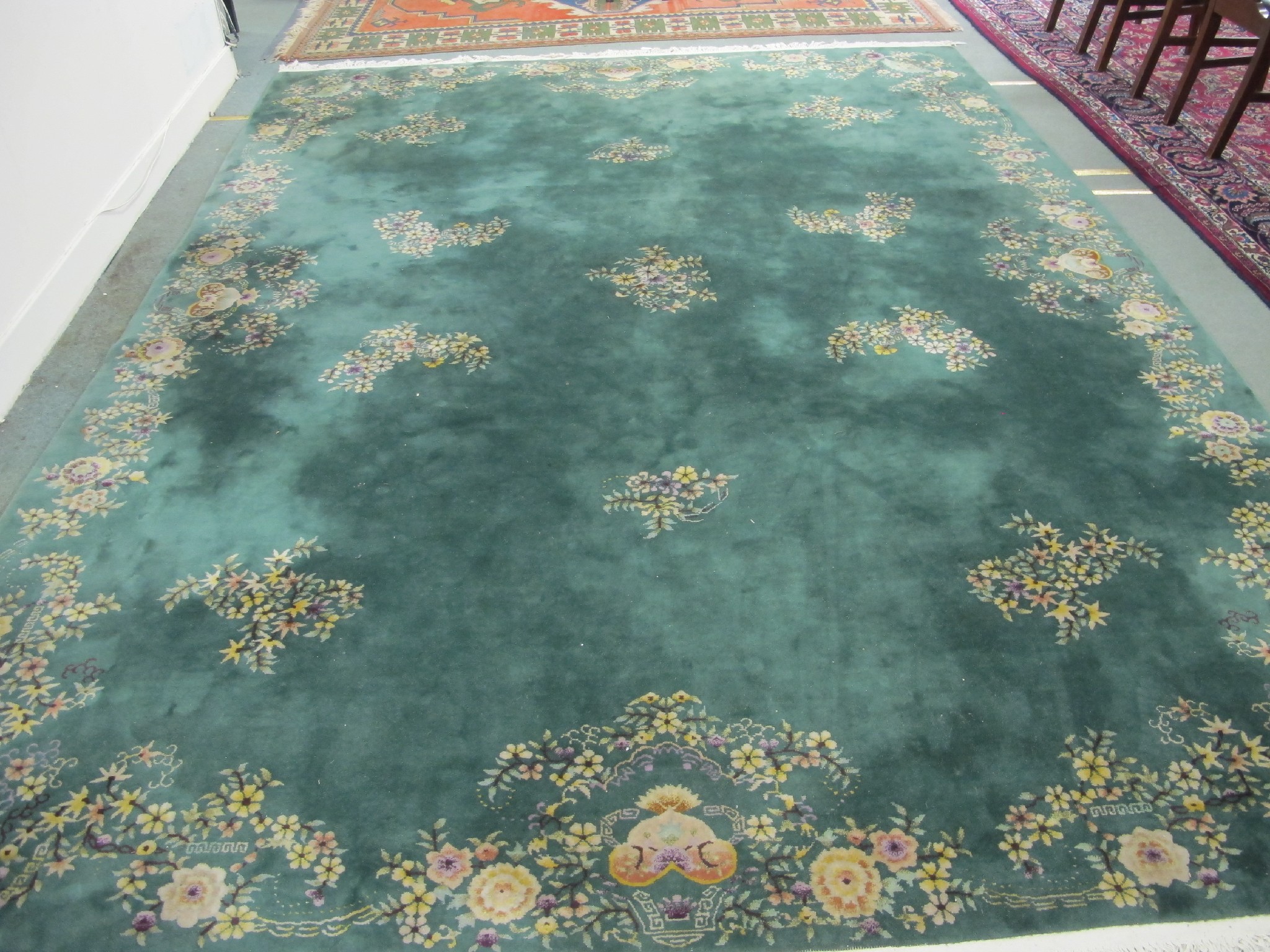 Appraisal: A large green ground carpet decorated with scattered flowers