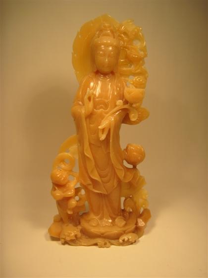 Appraisal: Chinese yellow soapstone QuanyinHalo surmounts standing immortal grasping water vase