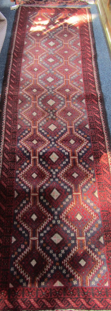 Appraisal: A Baluch runner decorated with geometric motifs against a grey