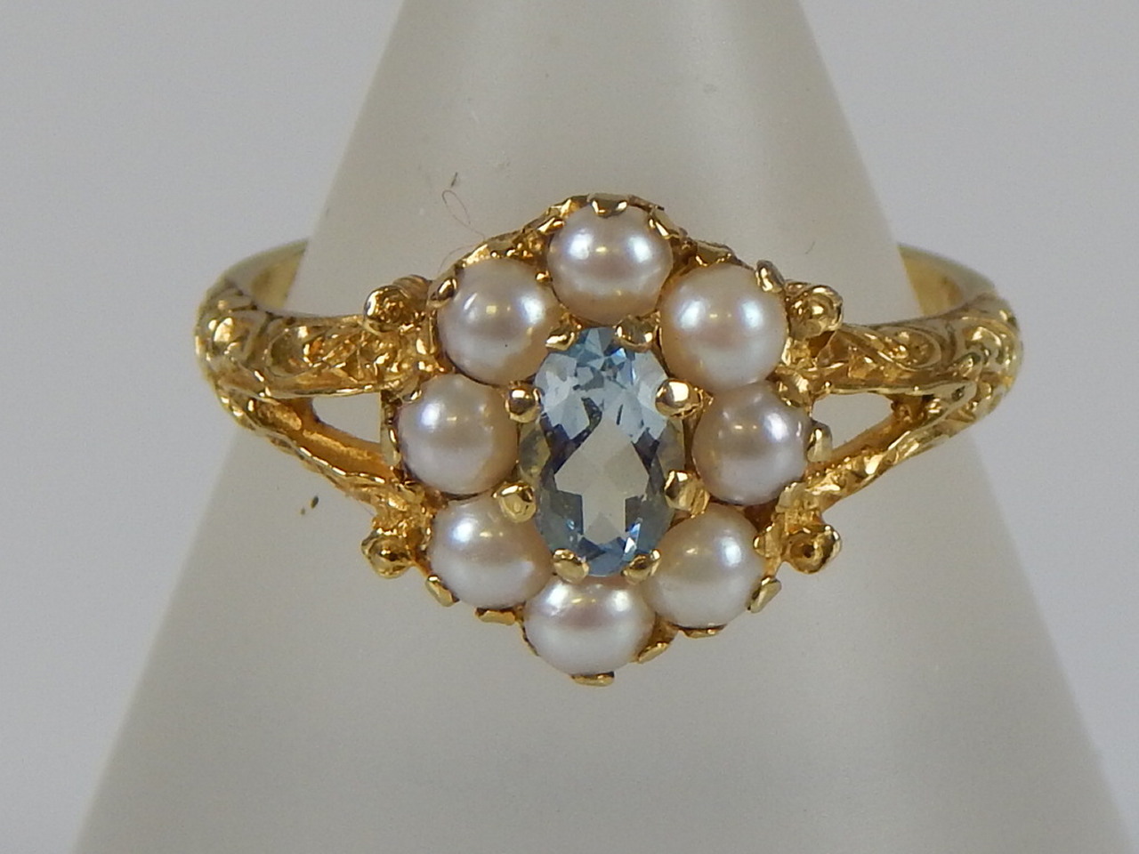 Appraisal: A ct gold dress ring with central blue topaz surrounded