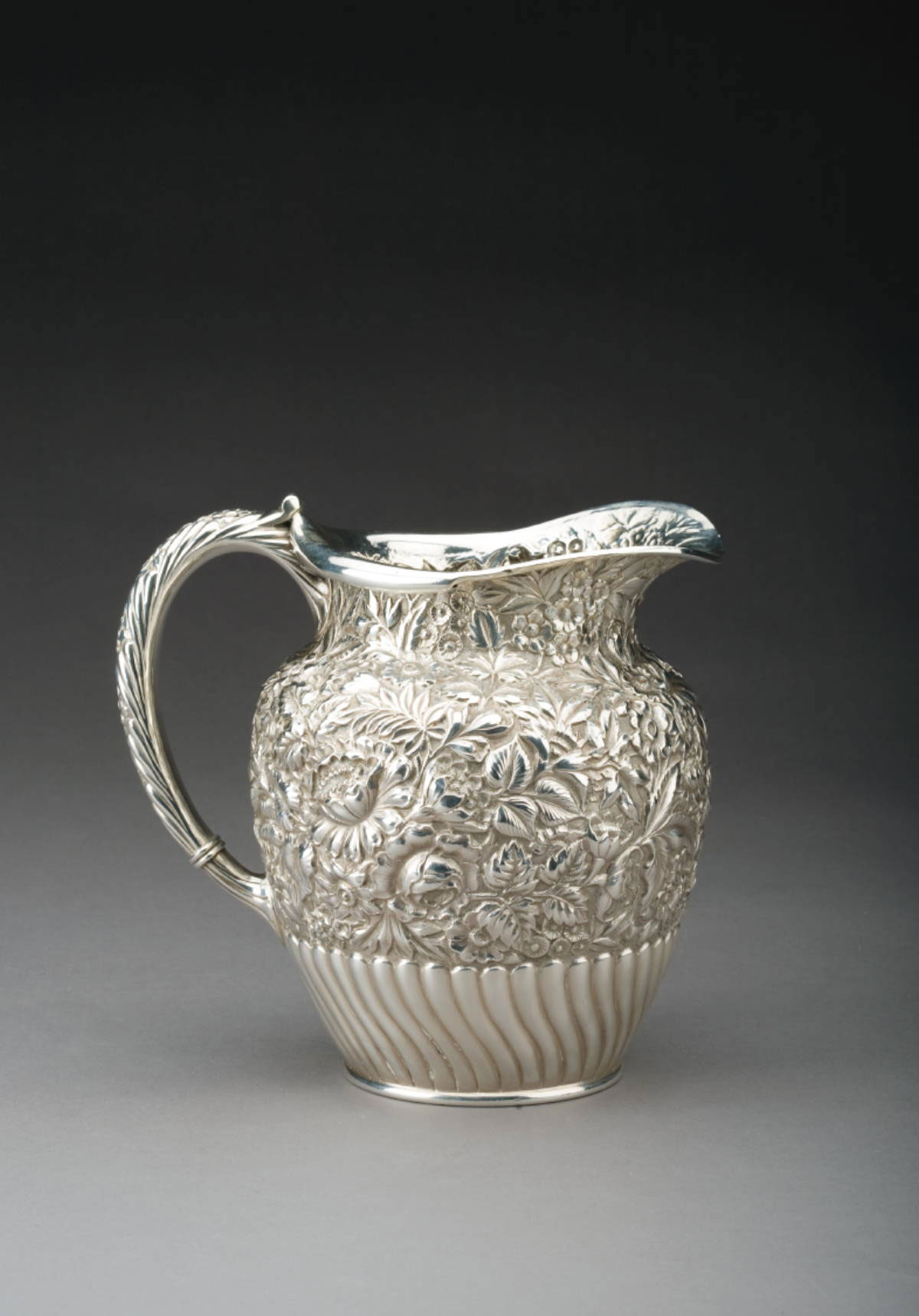 Appraisal: AMERICAN SILVER WATER PITCHER NINETEENTH CENTURY Densely repousse with flowers