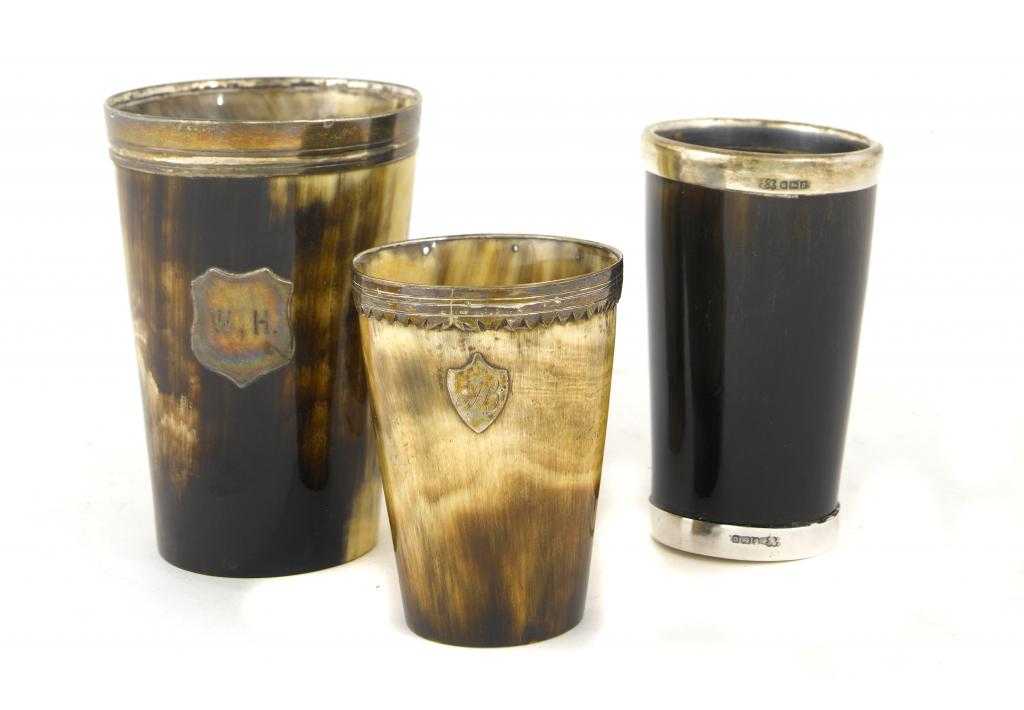 Appraisal: THREE SILVER MOUNTED HORN BEAKERS one with wood inset base