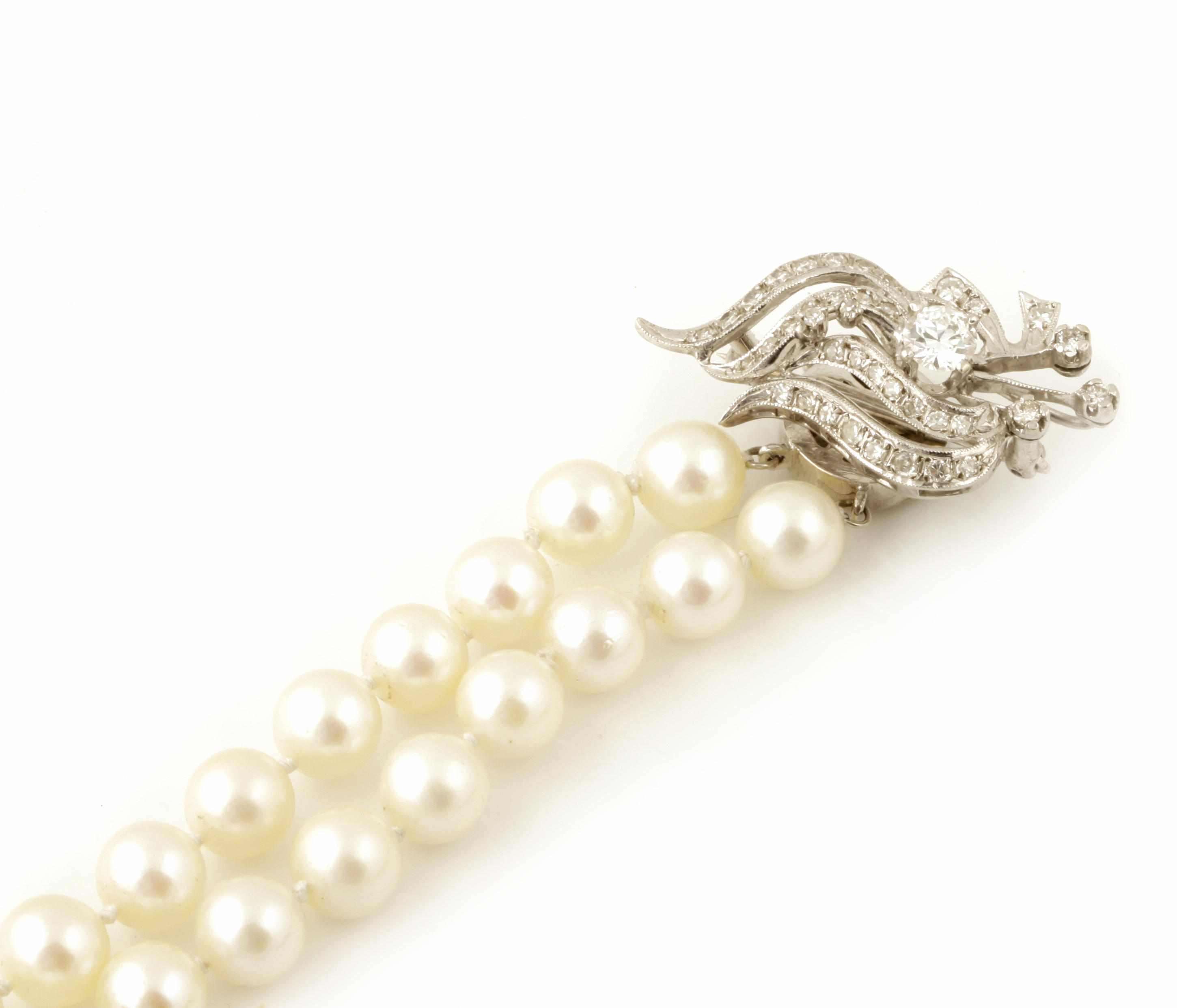 Appraisal: A cultured pearl double strand necklace with a diamond and