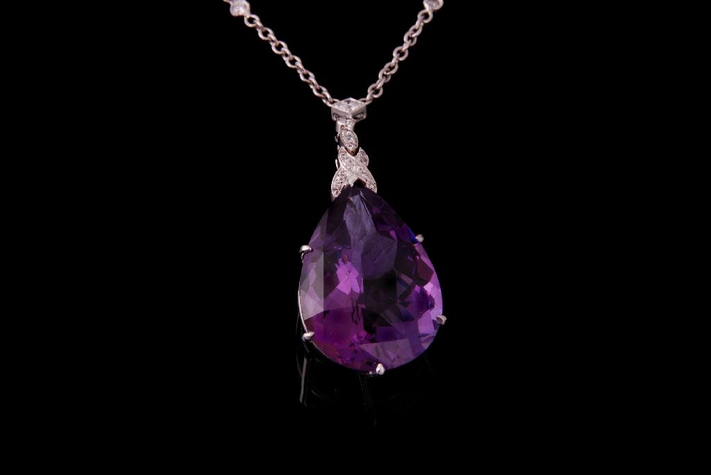 Appraisal: AN AMETHYST AND DIAMOND PENDANT the pear-cut amethyst claw set