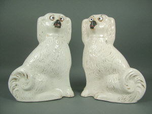 Appraisal: A pair of white and gilt highlighted Staffordshire spaniels late