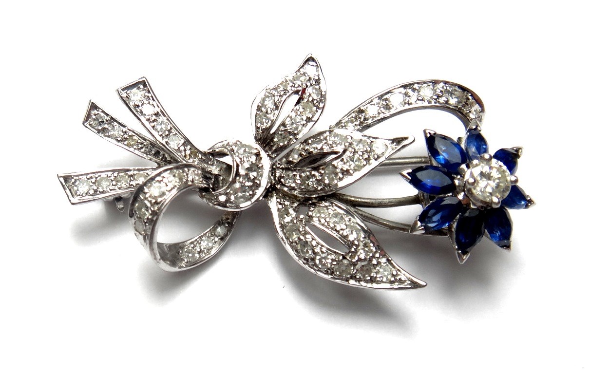 Appraisal: A diamond and sapphire set brooch designed as a bound