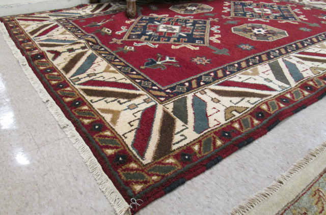 Appraisal: HAND KNOTTED ORIENTAL CARPET Indo-Kazak geometric design on red ground