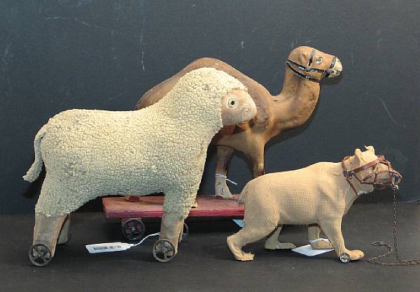 Appraisal: Grouping of Wheeled Animals German papier-mache camel a felt lamb