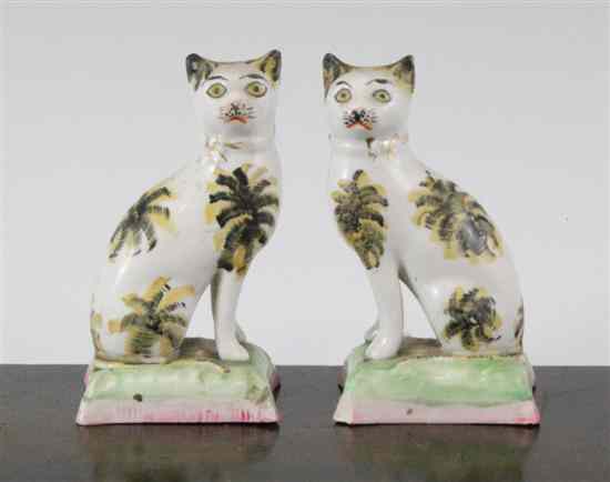 Appraisal: A pair of Staffordshire semi-porcellaneous seated figures of cats th